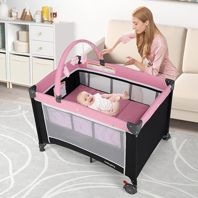 BABY JOY 3 in 1 Pink Pack and Play, Travel Baby Crib Bassinet Bed with Bassinet for Girl, Changing Table w/Safety Belt, Toy Bar, Lockable Wheels, Portable Baby Playard from Newborn to Toddler