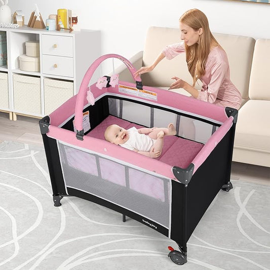 BABY JOY 3 in 1 Pink Pack and Play, Travel Baby Crib Bassinet Bed with Bassinet for Girl, Changing Table w/Safety Belt, Toy Bar, Lockable Wheels, Portable Baby Playard from Newborn to Toddler